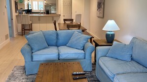 A living room with a sectional sofa, a coffee table, and a lamp. - Cozy 2-bed/2 bath condo in Saddlebrook Resort (Zephyrhills)