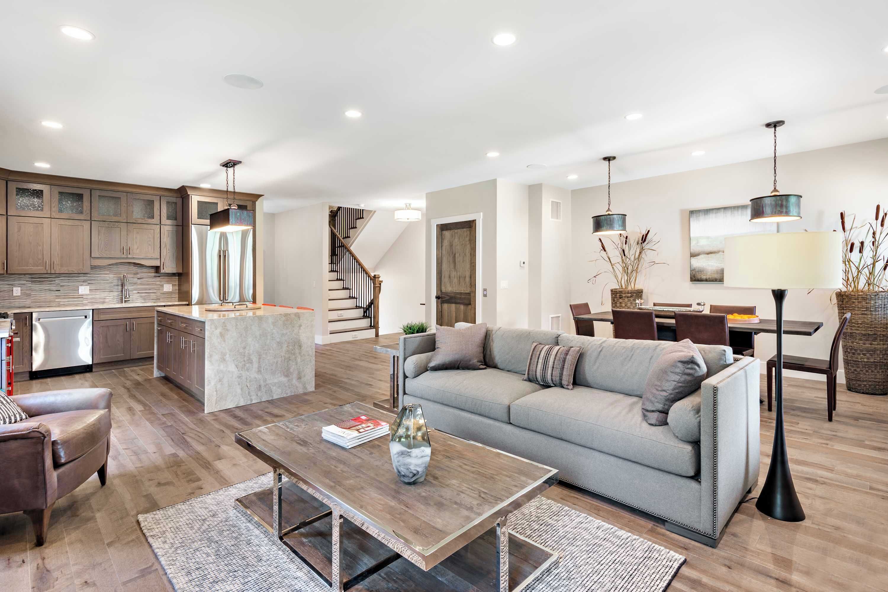 A modern living space with a kitchen, dining area, and a sofa set.
