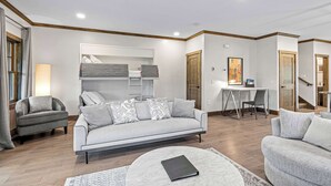 Un salon moderne comprenant un canapé, une table basse ronde, un bureau et une armoire.