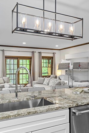 A modern kitchen with a granite countertop, stainless steel sink, and a built-in oven.