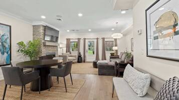 Tilava olohuone, jossa on ruokailutila, kivestä tehty korosteseinä ja suuri ikkuna.