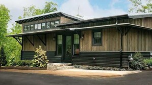 Un bâtiment moderne à deux étages, doté d’une façade en bois, de grandes fenêtres et d’un porche abrité.