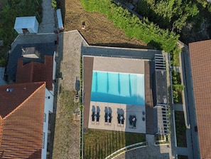 An aerial view of a swimming pool area with a rectangular pool, sun loungers, and a covered seating area. - Peaceful Farmhouse Stay in Parada de Tibães Portugal Surrounded by Nature (Braga)