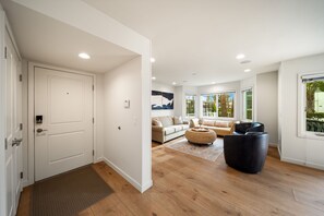 A modern living room with a sofa, ottoman, and a black chair. - The Famous Big Blue Units 1 & 4 (San Diego)