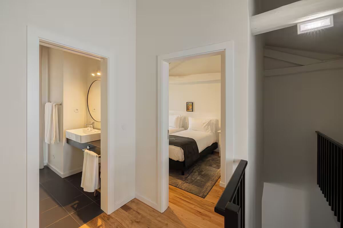 Una habitación de hotel moderna con baño, cama y escalera.