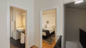 Una habitación de hotel moderna con baño, cama y escalera.