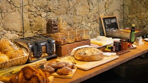 Een ontbijtbuffet met diverse soorten eten, zoals brood, gebak en toevoegingen.