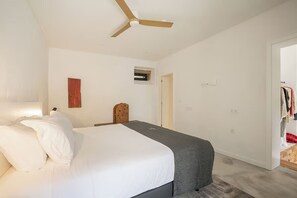 A bedroom with a bed, a ceiling fan, a small window, and a door leading to a closet. - Relaxing Rural Escape - Junior Suite with Pool Access and Scenic Views (Braga)