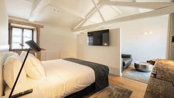 Une chambre à coucher avec un lit, un bureau, une chaise, une télévision et une fenêtre.