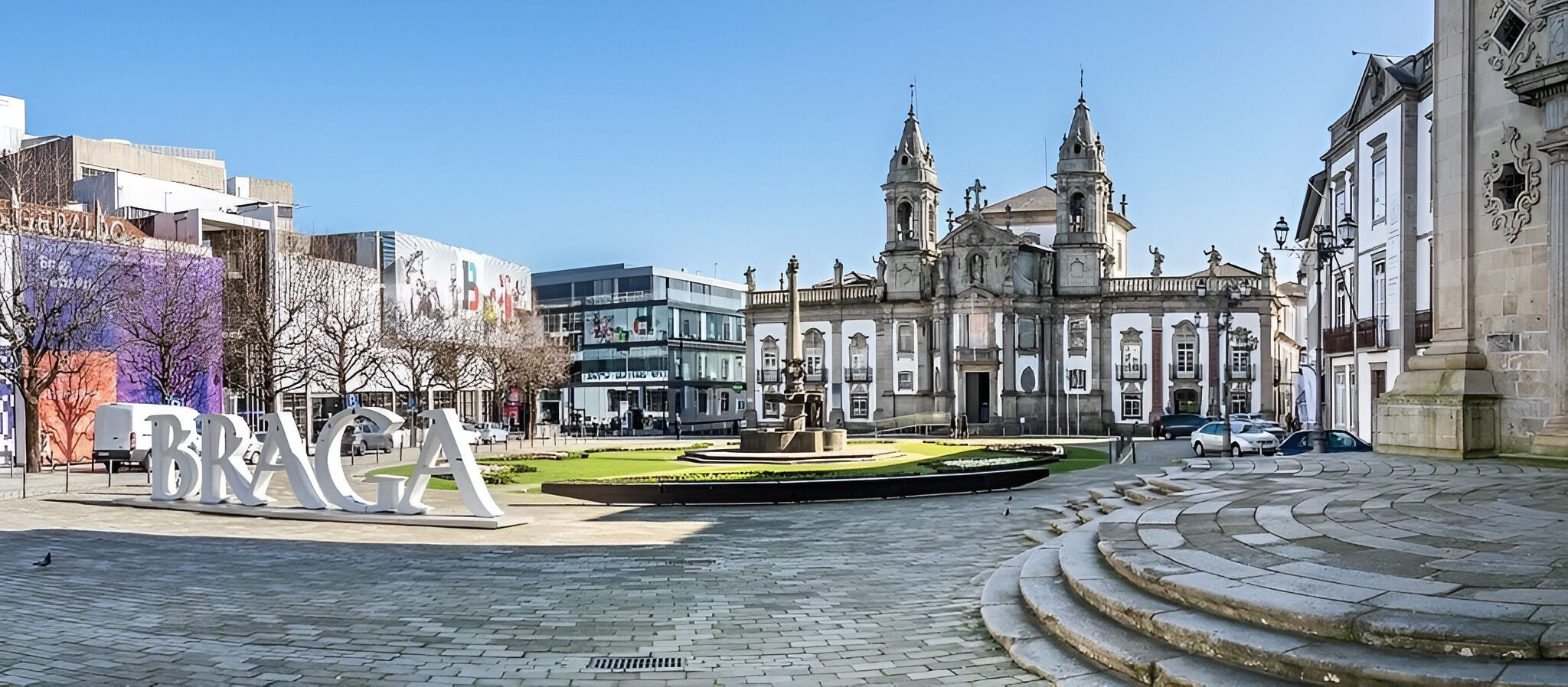A plaza with a fountain, a large 'BRAGA' sign, and historic buildings in the background.