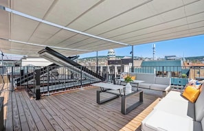 A rooftop deck with a staircase, outdoor seating, and a view of the cityscape. - AN EXCEPTIONAL BLEND OF ELEGANCE, COMFORT WITH BREATHTAKING ROOFTOP TERRACES (Zürich)