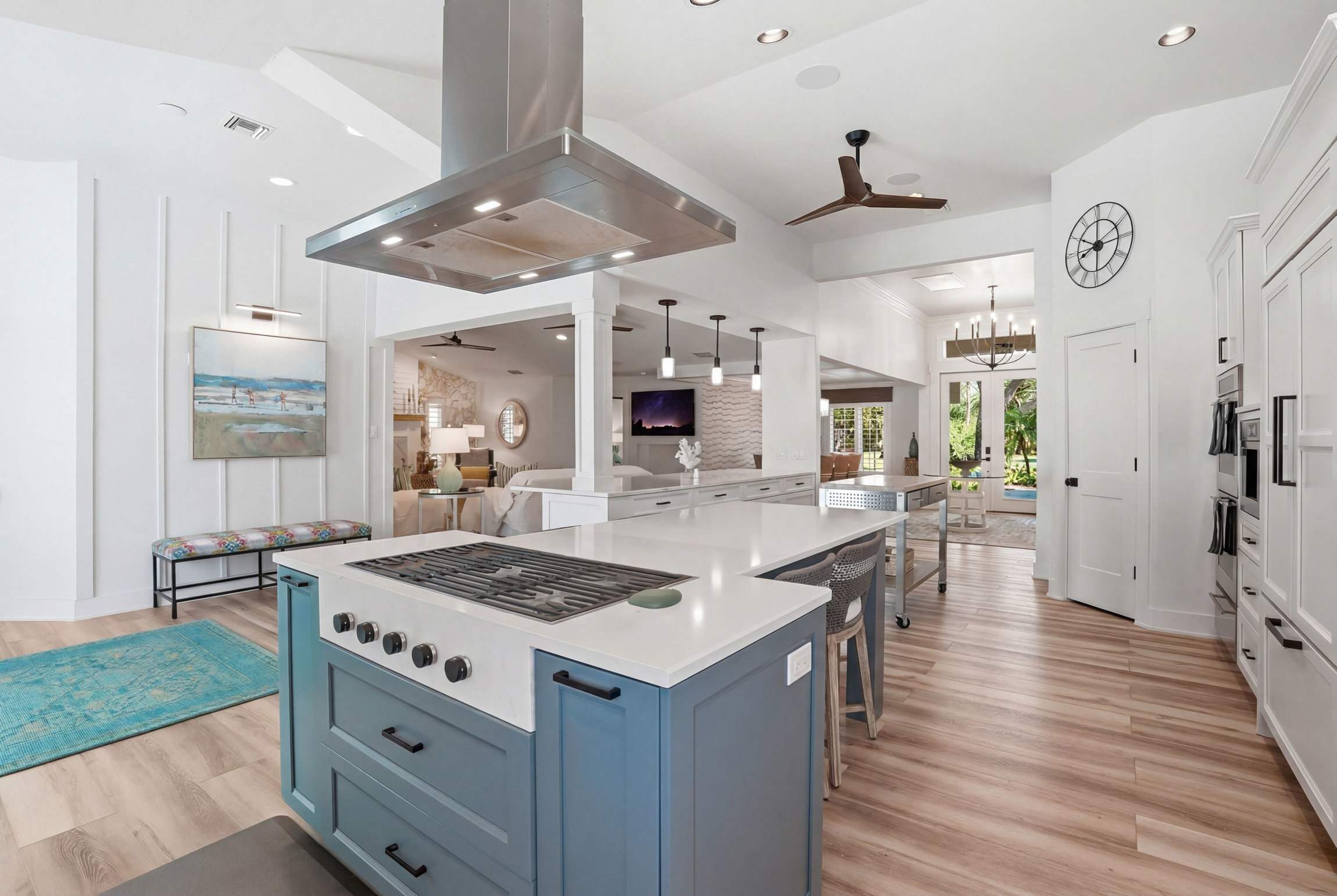A modern kitchen with a central island, built-in appliances, and a view to the outdoors.