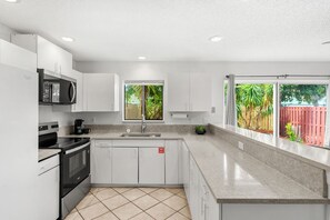 A modern kitchen with a built-in oven, microwave, and sink. - 217 Cherie Down Ln (Cape Canaveral)