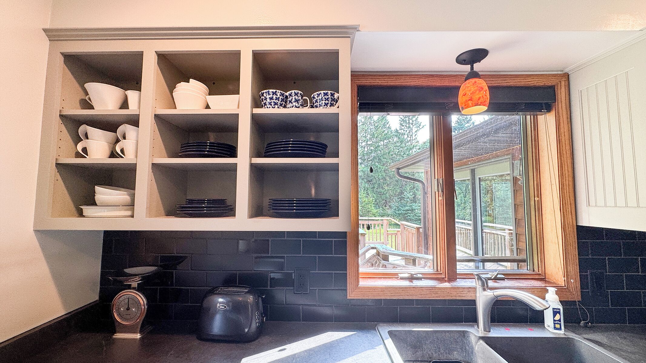 Una cocina con un mueble empotrado, una ventana con vistas, un lavabo y un tostador.