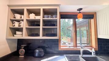 Una cocina con un mueble empotrado, una ventana con vistas, un lavabo y un tostador.