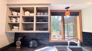A kitchen with a built-in cabinet, a window with a view, a sink, and a toaster.