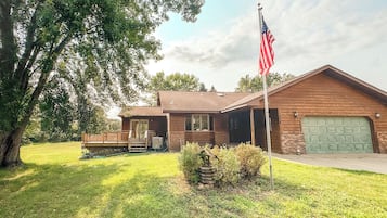 Et toetagers hus med garage, en veranda og et amerikansk flag.