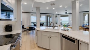 A modern kitchen with a built-in oven, a coffee maker, and a dishwasher. - 1617 Lands End Village | Best View on Captiva! (Captiva)