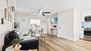 A modern apartment with a living room, dining area, kitchen, and a ceiling fan. - 221 Madison Ave - Unit B (Cape Canaveral)