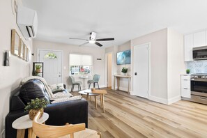 Um apartamento moderno com sala de estar, sala de jantar, cozinha e ventilador de teto.
