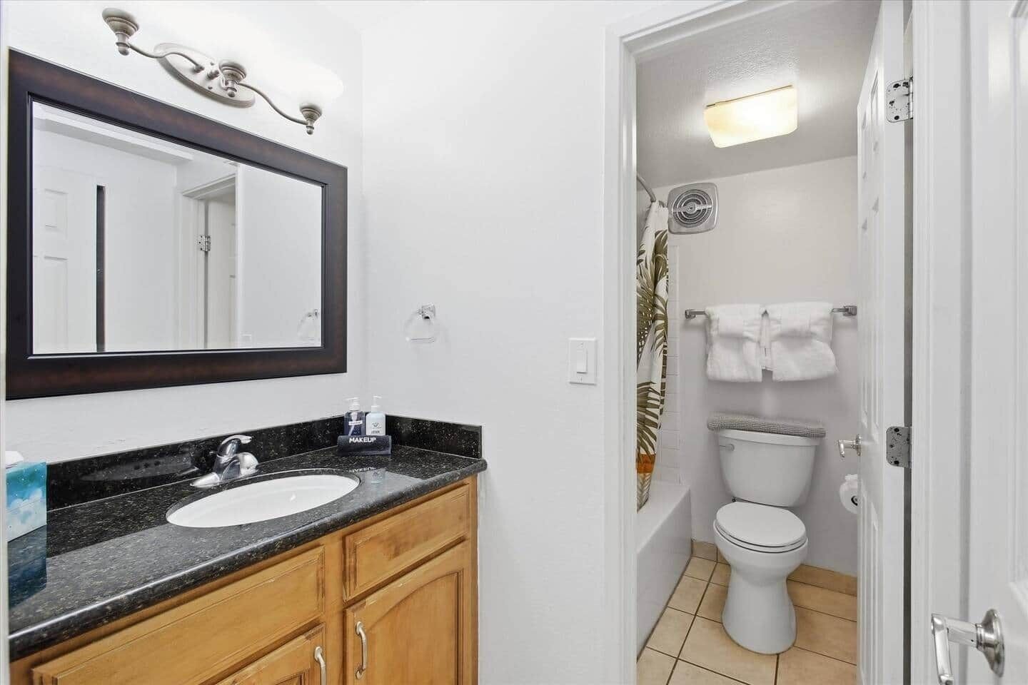 A bathroom with a sink, mirror, and toilet.