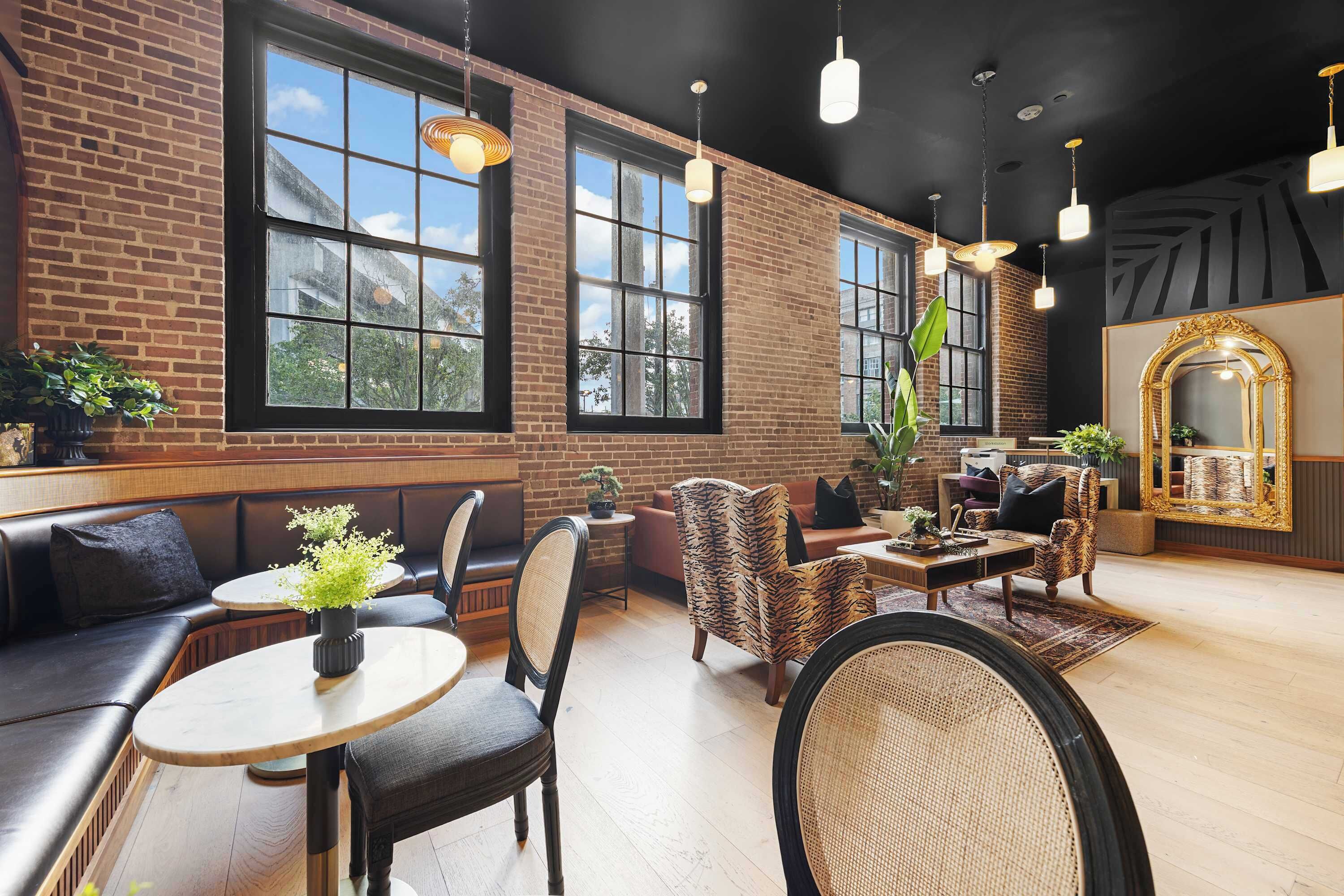 A spacious lounge area with leather seating, a coffee table, and a large mirror.
