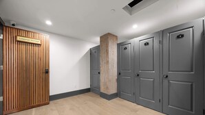 A hotel room with a luggage storage area, grey doors, and a wooden panel wall. - The Perfect Layout for a Memorable Stay! All Kings (New Orleans)