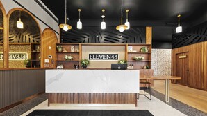 En receptionsdisk med en skylt som visar texten ”ELEVEN48” och en skylt under som anger ”NEW ORLEANS LUXURY COLLECTION”.