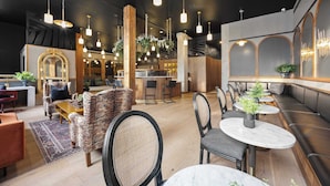Ein modernes Interieur mit Sitzbereichen, einer Bar und einer Rezeption.