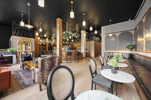 A modern interior with seating areas, a bar, and a reception desk. - Boutique 1BR Suite | Rooftop | Convention Ctr (New Orleans)