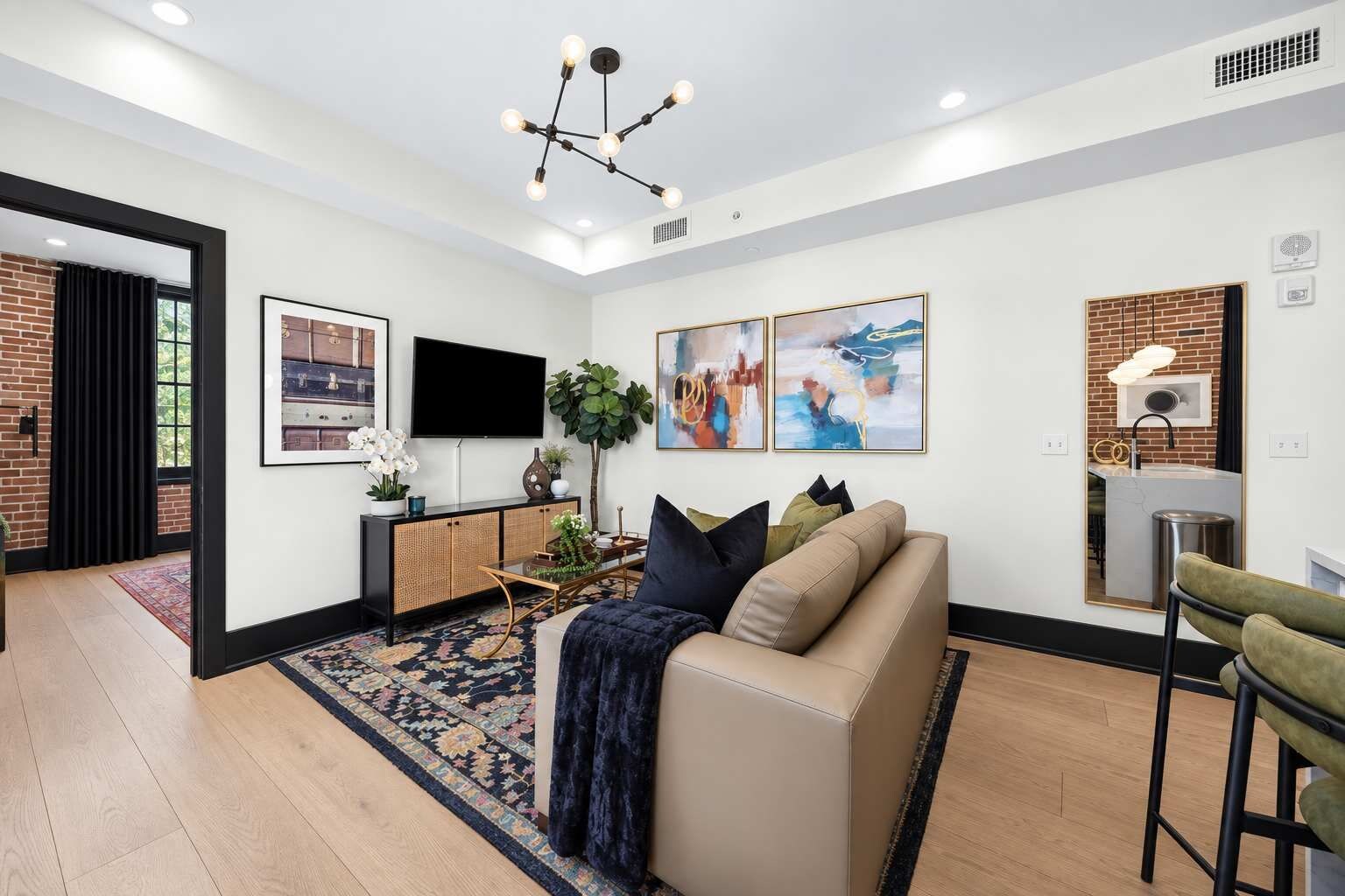 Una sala de estar moderna con sofá, mesa de centro y una obra de arte en la pared.