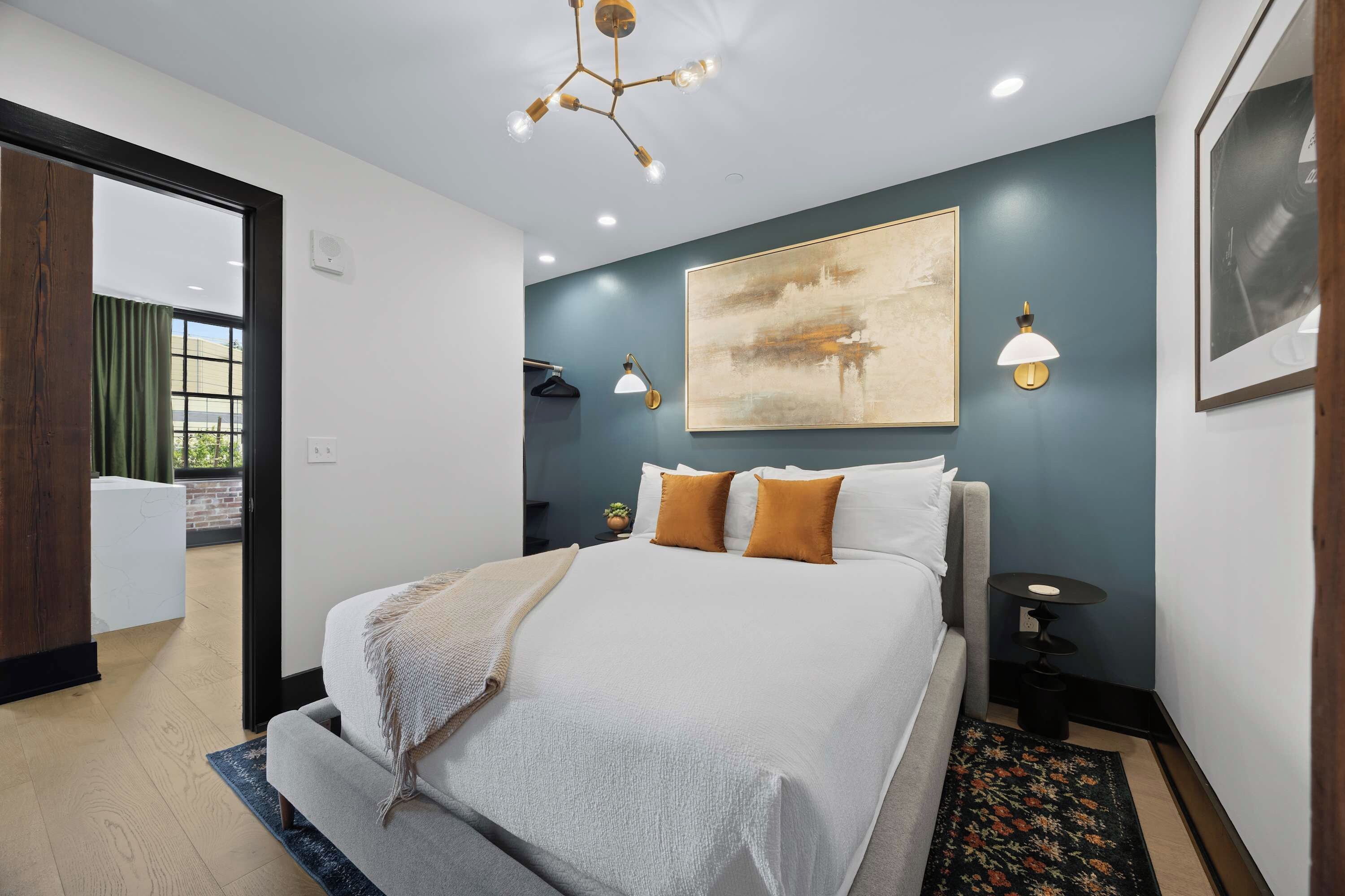 Un dormitorio moderno con una cama grande, una lámpara de techo y una lámpara de pared.