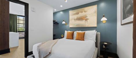 Un dormitorio moderno con una cama grande, una lámpara de techo y una lámpara de pared.