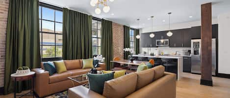 Un salon moderne avec un canapé, une table basse et un coin repas avec des chaises.