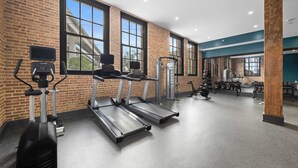 A gym with treadmills, weight machines, and a wall of dumbbells. - All New | King bed | Gym | Rooftop (New Orleans)