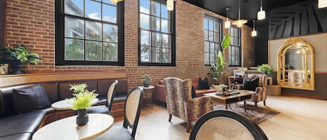 A spacious lounge area with leather seating, a coffee table, and a large mirror.