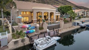 A resort with a pool, outdoor seating, and a boat docked by the water. - The Estate | Lake Views w/Heated Pool, Spa, & Boat (Glendale)