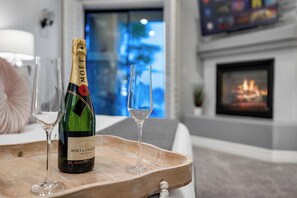 Eine Flasche Moët & Chandon Champagner auf einem Tablett mit zwei Gläsern, einem Kamin und unscharfem Hintergrund.