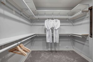 Ein Zimmer mit grauem Teppich, weißen Wänden und einer Decke mit freiliegenden Balken und Beleuchtung.