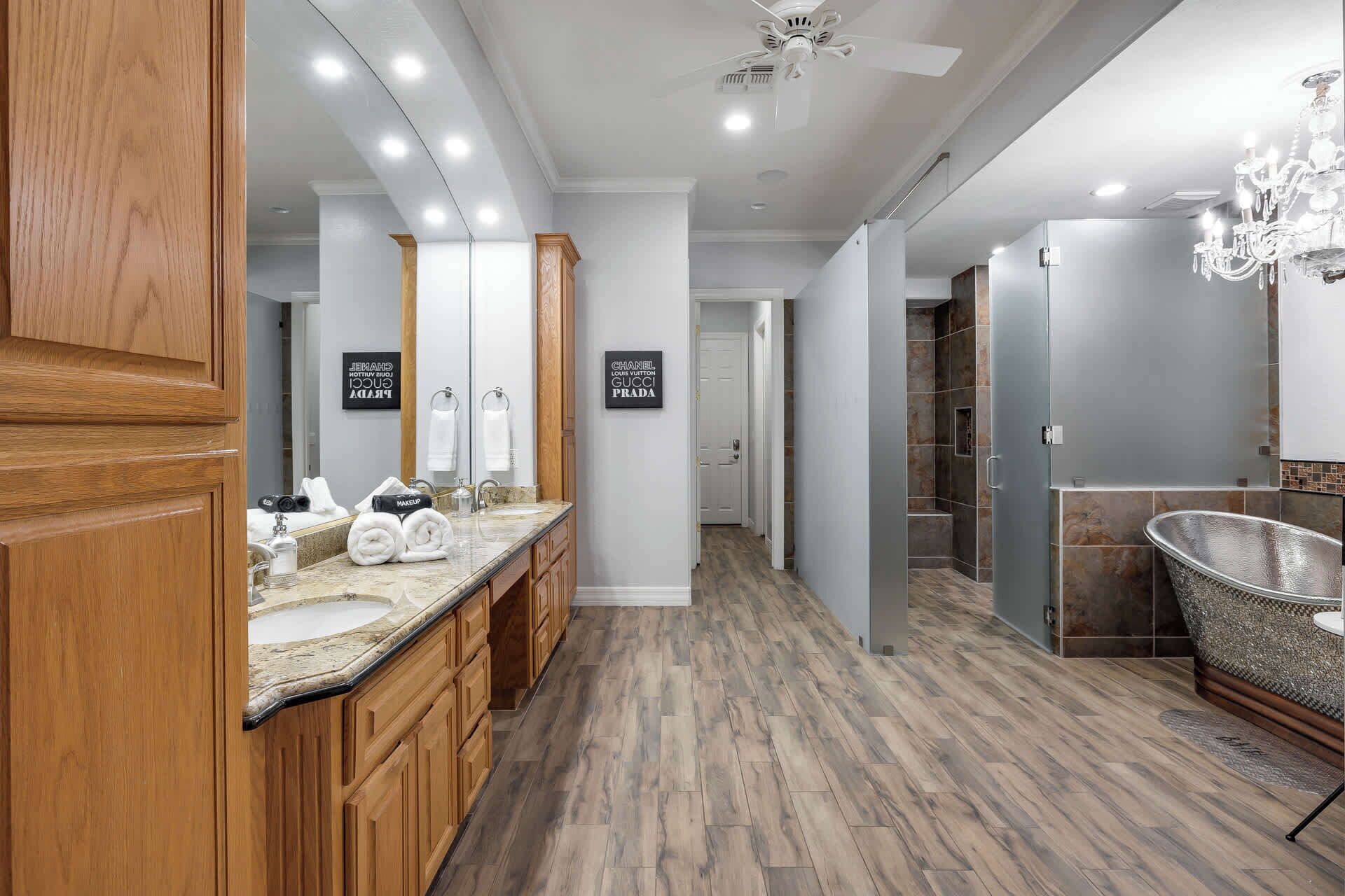 Une salle de bain moderne avec un meuble-lavabo en bois, un grand miroir et un espace douche.