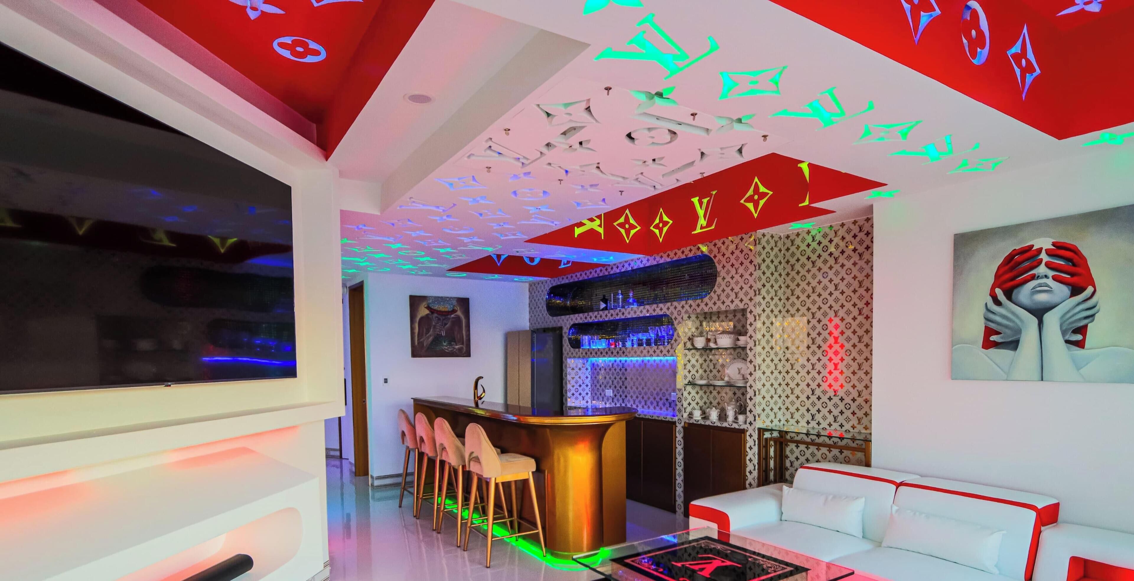 Un intérieur moderne avec un espace bar, des sièges et un mur orné de motifs.
