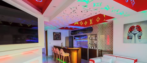Un interior moderno con barra, asientos y una pared con diseño.