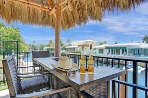 Ein Balkon mit Korbmöbeln, einem Tisch und zwei Flaschen Corona Bier.