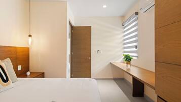 Ein modernes Schlafzimmer mit Bett, Nachttisch, Lampe, Kleiderschrank und einem Fenster mit Jalousien.