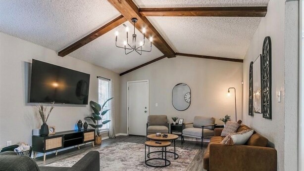 A living room with a flat-screen TV, two sofas, a coffee table, and a chandelier. - Newly Remodeled 3 BR House w/ Fire Pit, 5 min. From Stadium! (Norman)