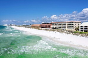 A beachfront hotel with multiple buildings, a sandy beach, and ocean waves. - Dunes of Crystal Beach 404 - Beachfront Condo with Community Pool in Destin (Destin)
