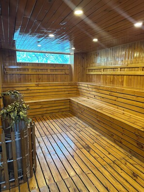 Uma sala de sauna com bancos de madeira e uma janela grande.