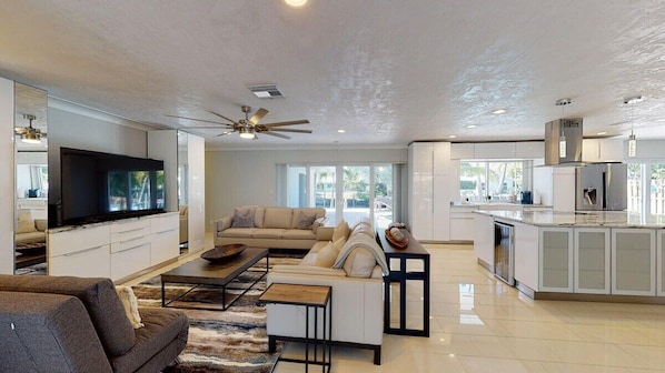 A spacious living area with a sofa, coffee table, and a TV. - Villa by the Sea (Fort Lauderdale)