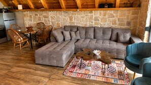 Ein gemütliches Wohnzimmer mit einer Eckcouch, einem Couchtisch und einem gemusterten Teppich.