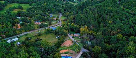 An aerial view of a residential area with houses, roads, and a large green park.